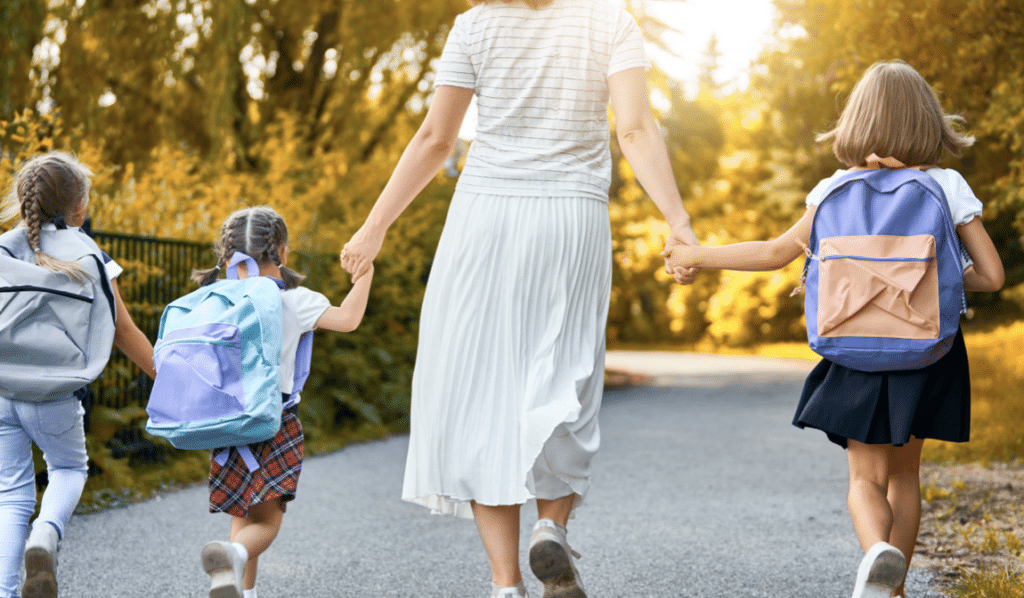 Champagne-sur-Seine : Maman tenant la main à des enfants avec un cartable sur le dos